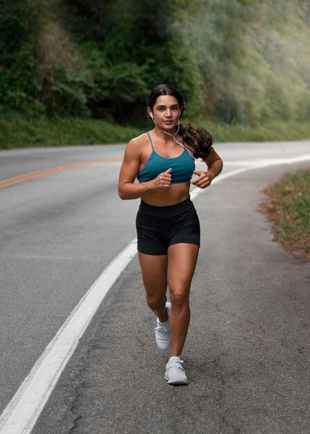 Full shot fit woman running outdoors