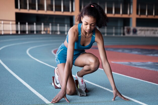 ランニングスタートラインでのフルショットフィットの女性