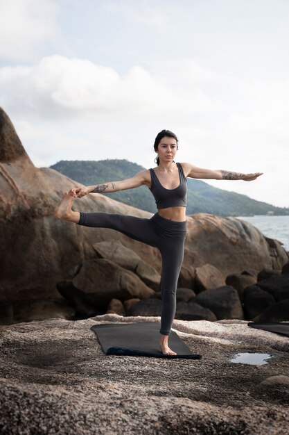 Full shot fit woman standing on one leg