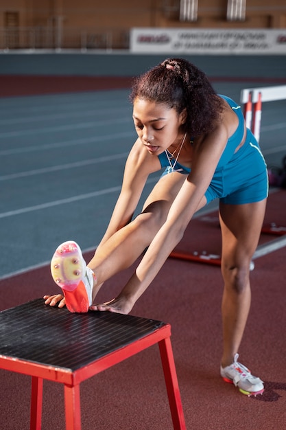 Full shot fit woman stretching with equipment