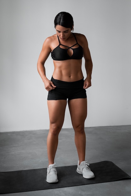 Free photo full shot fit woman training indoors