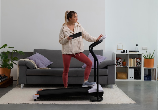 Free photo full shot fit woman on treadmill