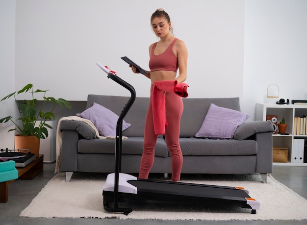 Foto gratuita donna in forma a figura intera con tapis roulant