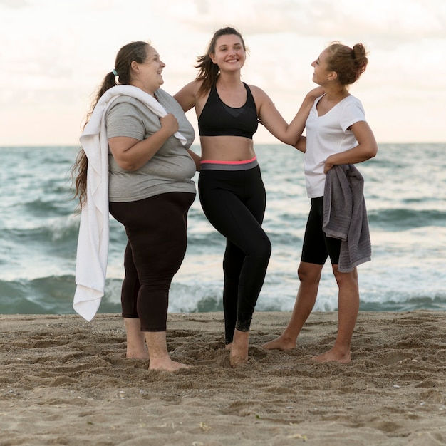 Foto gratuita amici di fitness full shot in spiaggia