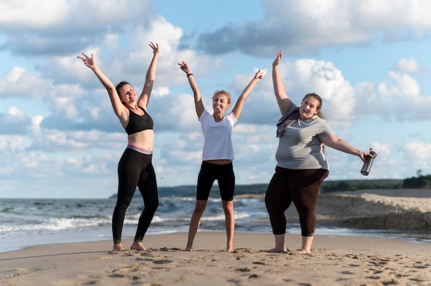 Amici di fitness full shot in spiaggia