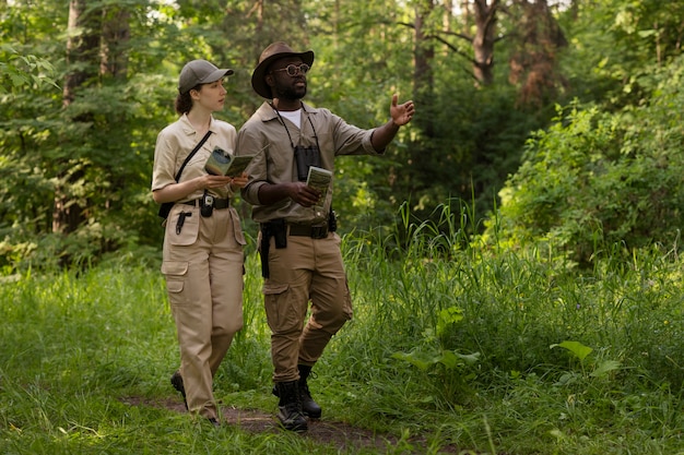 Free photo full shot forest wardens in nature