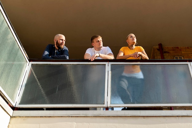 Des amis profitant d'un balcon muni d'un garde-corps sécurisé Des amis profitant d'un balcon muni d'un garde-corps sécurisé