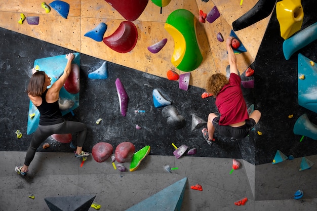 Full shot friends climbing wall together