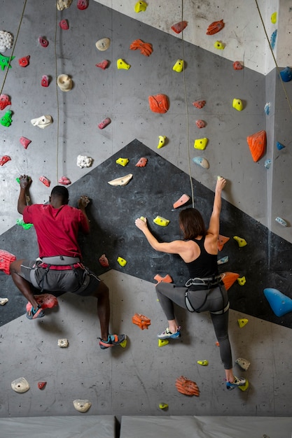 Full shot friends climbing wall together