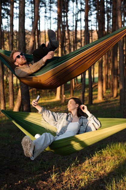 Full shot friends in hammocks