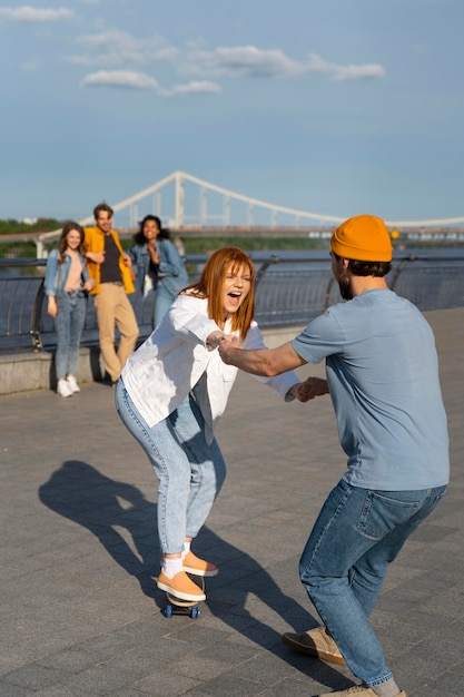 Free photo full shot friends having fun with skateboard