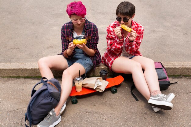 Full shot friends holding corn