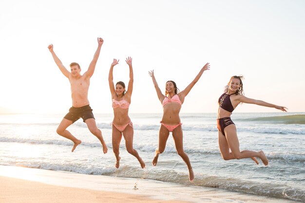 Full shot friends jumping on shore