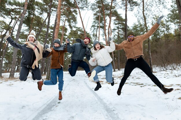 Full shot friends jumping winter time