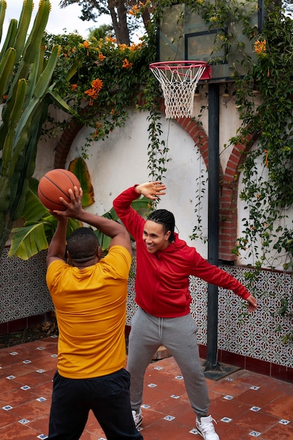 Free photo full shot friends playing basketball