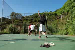 Free photo full shot friends playing soccer