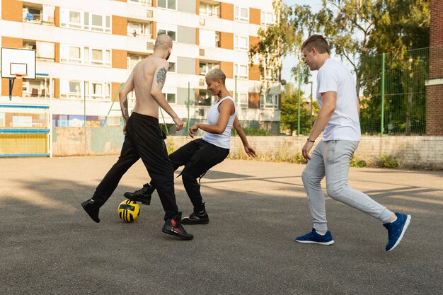 Друзья, играющие с мячом в пригороде