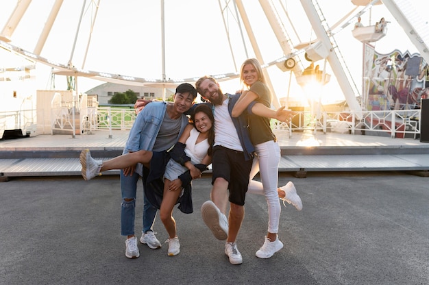 Free photo full shot friends posing at funfair