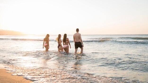 Full shot friends posing in sea