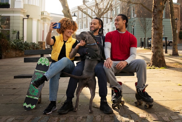 Free photo full shot friends sitting on bench