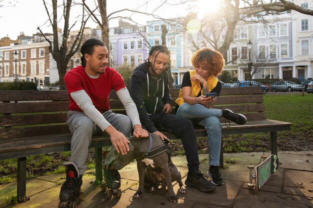 Free photo full shot friends sitting on bench