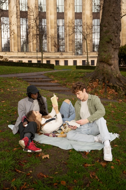 Full shot friends sitting on blanket