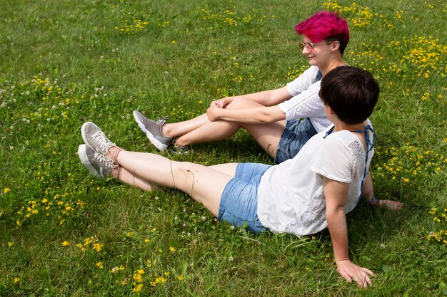 Full shot friends sitting on grass