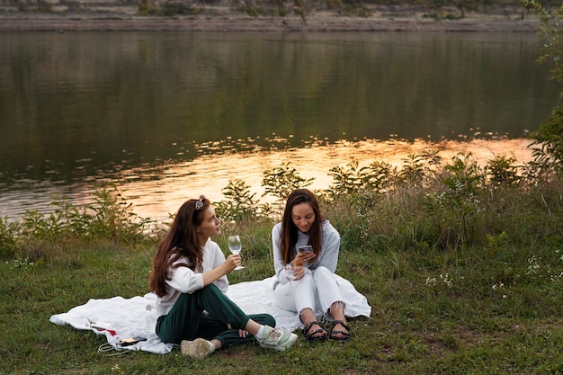 Free photo full shot friends sitting in nature