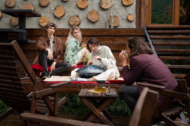 Full shot friends sitting outdoors