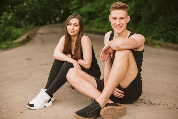 Free photo full shot friends sitting on the road