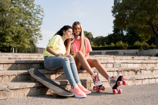 Free photo full shot friends sitting on stairs