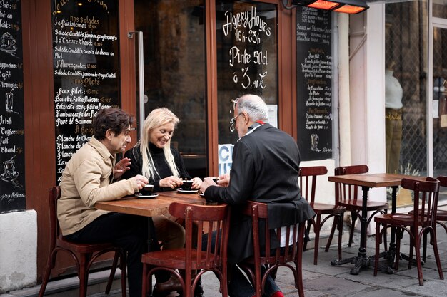 Full shot friends sitting together at bistro