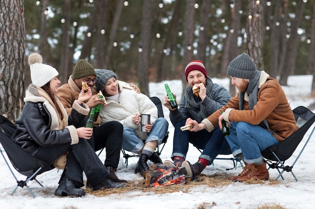 Full shot friends sitting together in nature