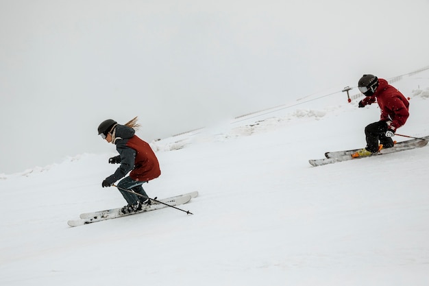 Free photo full shot friends skiing together