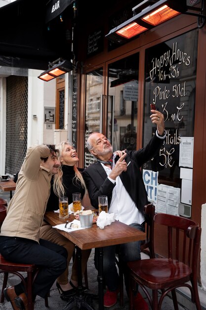 Full shot friends taking selfie with smartphone