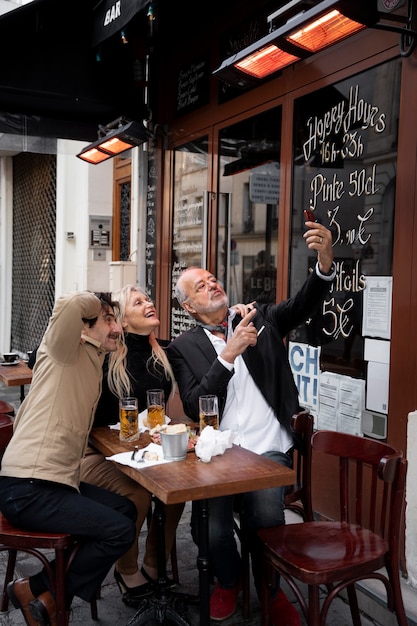 Full shot friends taking selfie with smartphone