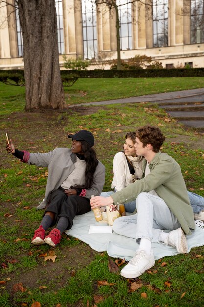 Full shot friends taking selfie
