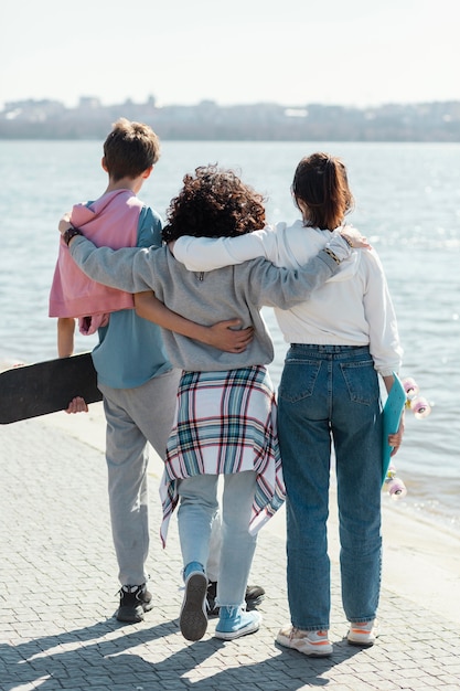 Free photo full shot friends together at seaside