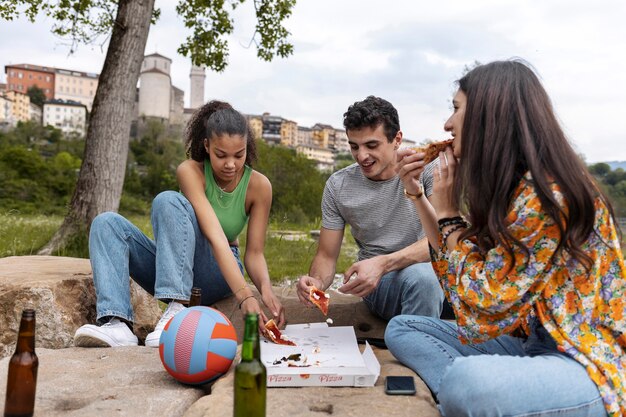 Full shot friends with delicious pizza