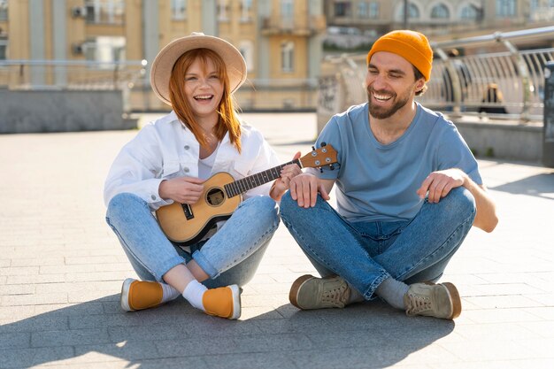 Full shot friends with guitar in city