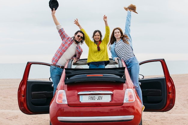 Free photo full shot friends with red car