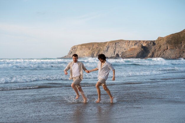 Полный снимок геев, держащихся за руки на пляже