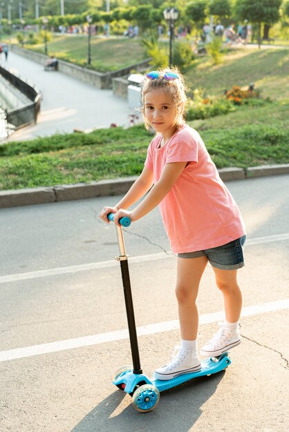 Full shot of girl on blue scooter