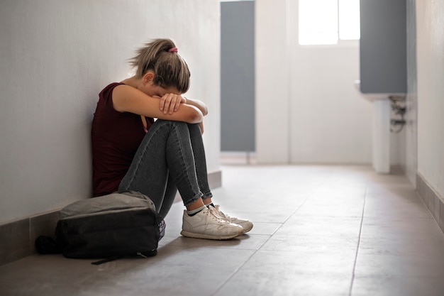 Full shot girl crying on floor