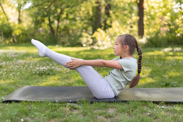 Бесплатное фото Полный снимок девушка, упражнения на коврик для йоги
