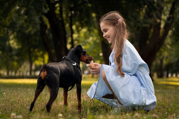 Full shot girl feeding dog