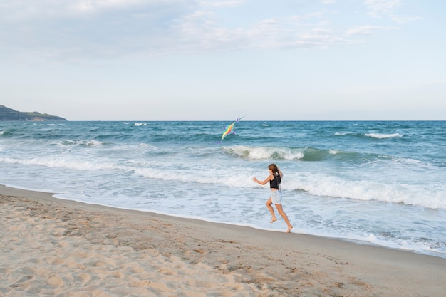 Free photo full shot girl having fun at the beach