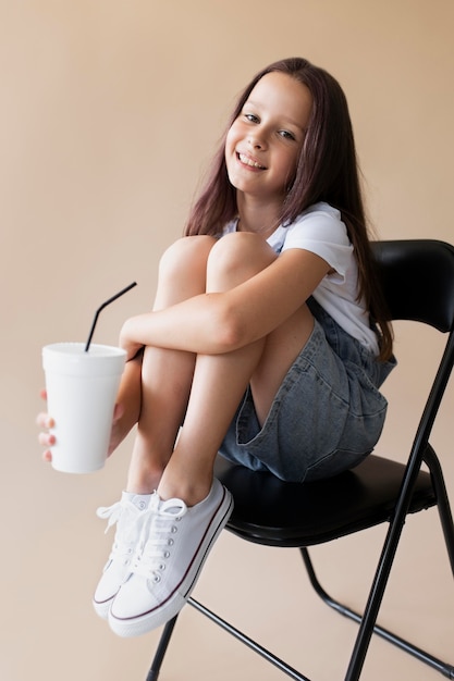 Free photo full shot girl holding cup