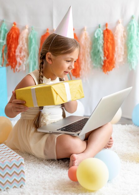 Free photo full shot girl holding laptop on legs