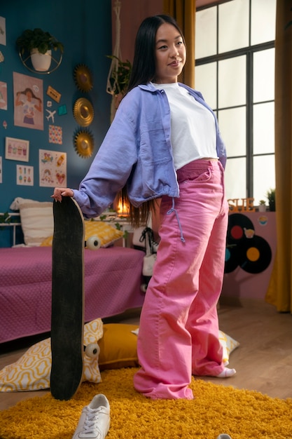 Free photo full shot girl holding skateboard